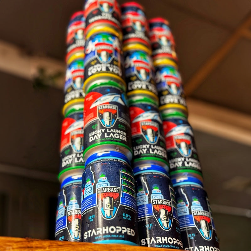 4 6-packs of Starbase Brewing beers stacked on top of each other. Photo taken from below for dramatic effect.