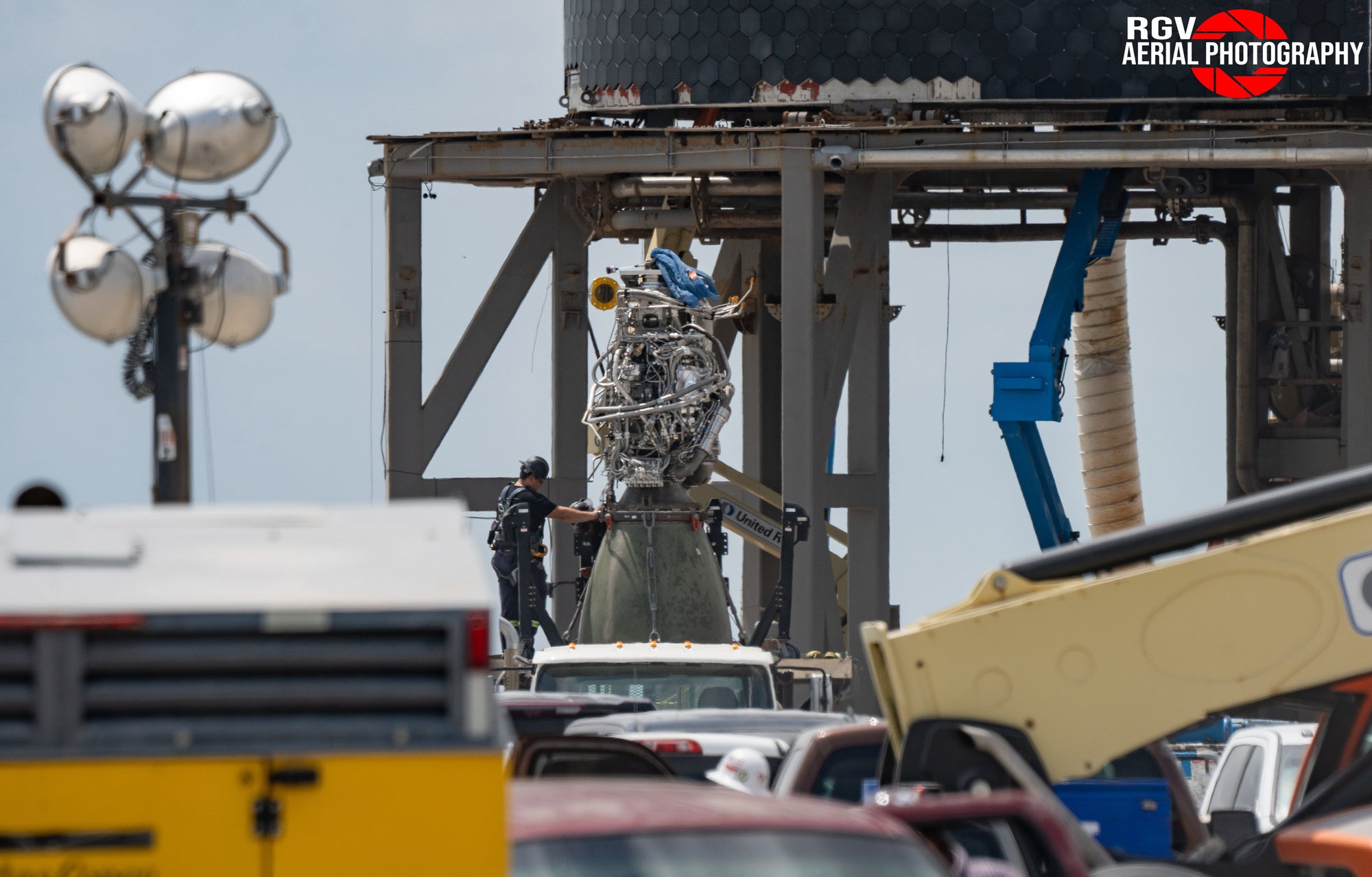 Raptor engine is installed by a SpaceX employee underneath Booster 20